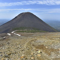 雌阿寒岳中腹からみる円錐形の阿寒富士と火山地帯の景観の写真