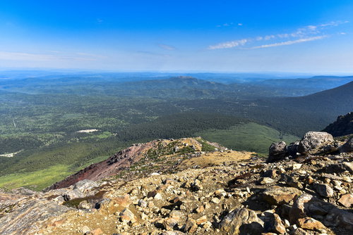 雌阿寒岳中腹の岩場から見る北の原生林と青空