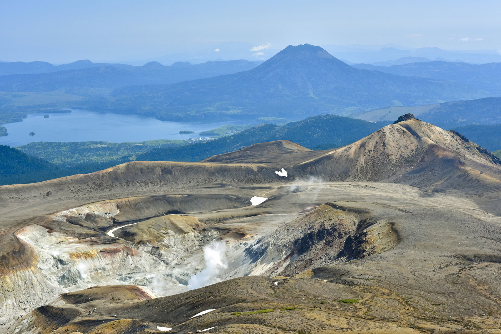 雌阿寒岳山頂から見た荒野と遠方の山々のパノラマ風景