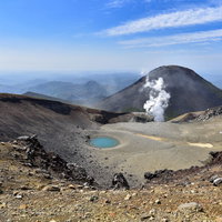 雌阿寒岳山頂から見るエメラルドグリーンの青池と阿寒富士の写真
