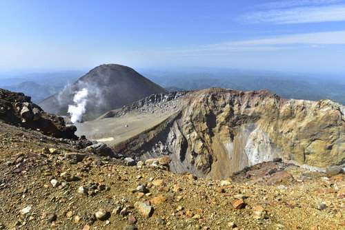 雌阿寒岳の火口と背後に聳える阿寒富士の雄大な火山風景