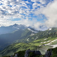 朝日に照らされる双六山荘方面と雲海に浮かぶ槍ヶ岳のシルエットの写真