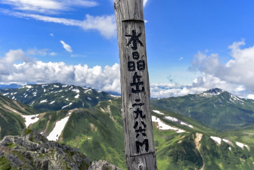水晶岳山頂碑と夏山の稜線