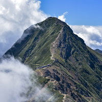 今にも雲に覆われそうな日本百名山の阿弥陀岳と赤岳の写真