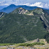 横岳から見る北八ヶ岳方面の山並みと赤岳の景色の写真