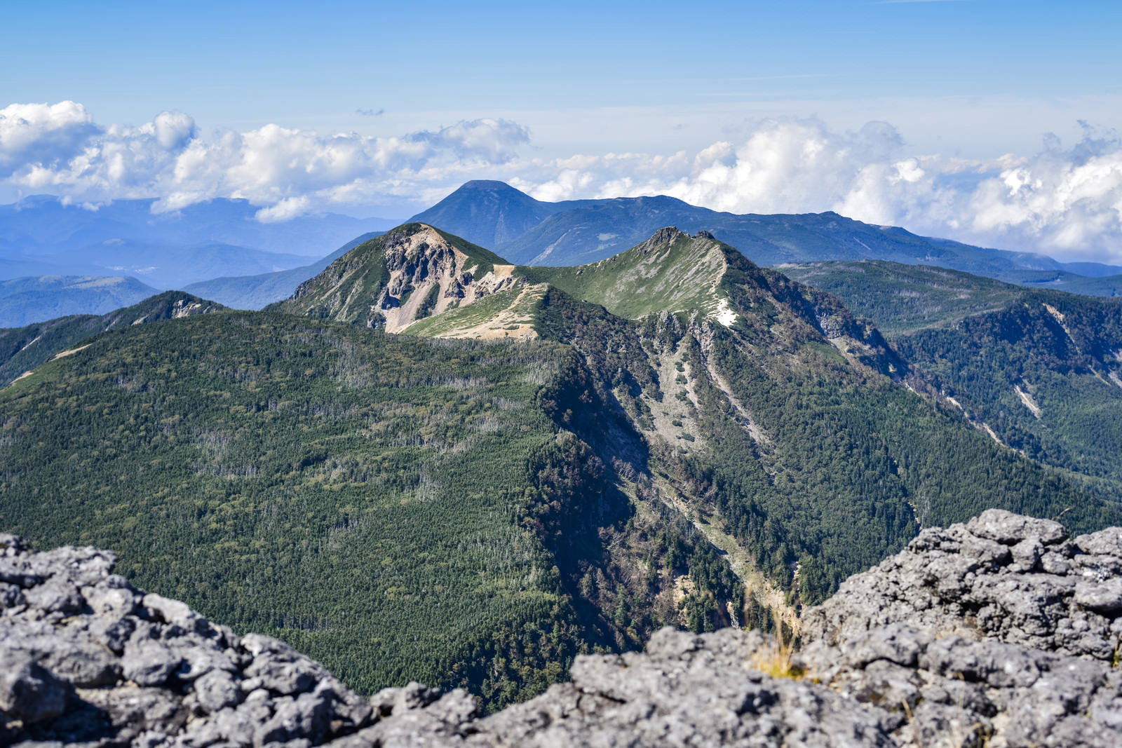 横岳の岩稜の向こうに見える蓼科山の山並みと雲海の風景