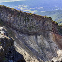 100名山・硫黄岳の爆裂火口の壁と赤岳を望む登山道の写真