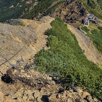 赤岳山荘へ向かう登山道の急峻な岩場につけられた鎖の写真