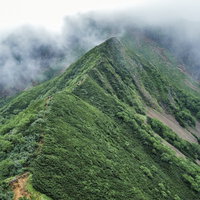 赤岳方面から見る雲がかかった阿弥陀岳側登山道の写真