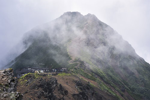 雲を纏う赤岳（あかだけ）と山小屋
