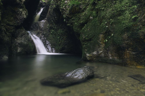 ネジレの滝に浮かぶ苔むした岩と静かな水面