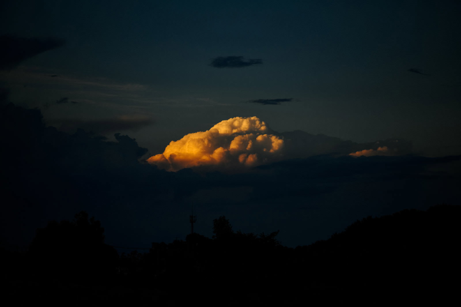 夕日に照らされオレンジ色に光る入道雲