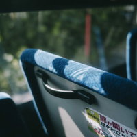 バスの座席と取っ手 青色シートとヘッドレスト付きの写真