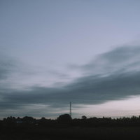 流れゆく雲とゆっくりとやってくる朝焼けの空の写真