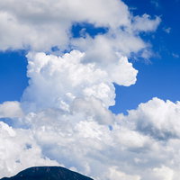 男体山の山頂にかかる巨大で真っ白な入道雲の写真