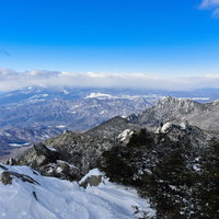 金峰山から望む冬の瑞牆山と雲に覆われた八ヶ岳の写真