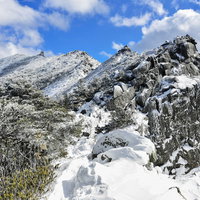 冬の金峰山千代ノ吹上、雪化粧した岩稜帯と青空の写真