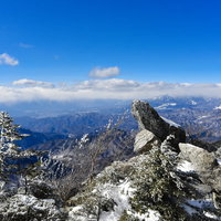 金峰山から望む砂払ノ頭と八ヶ岳の雪化粧した冬の岩場の写真