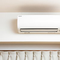 ワンルームのエアコンと窓辺のカーテンの写真