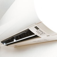 ワンルームの天井に設置された家庭用エアコンの写真