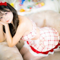 ソファーに座る赤いリボンのメイド服コスプレ女子の写真