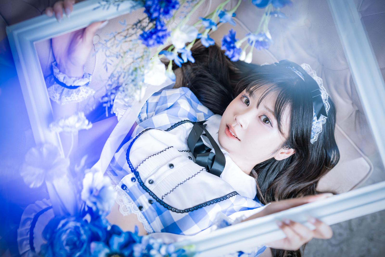 青い額縁の中でメイド服を着て横たわる女性のポートレート写真［モデル：れいか氏］