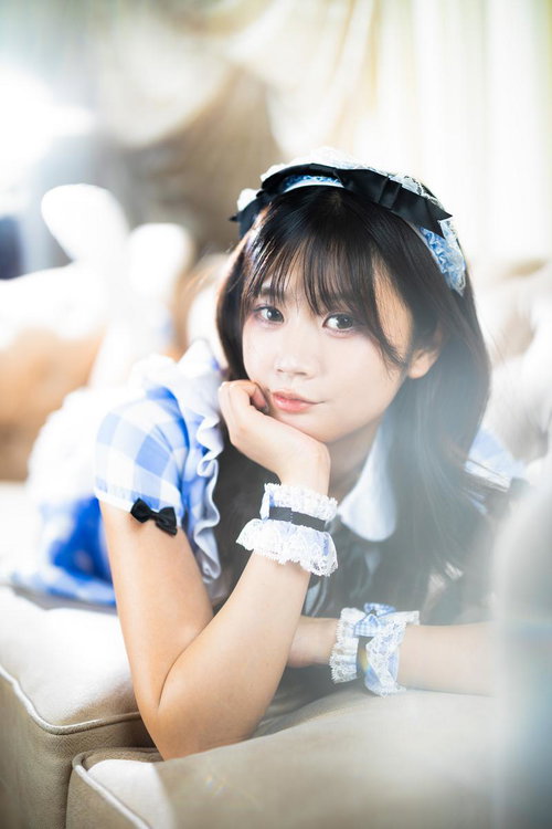 頬杖をついてこちらを見つめるメイド服の女性