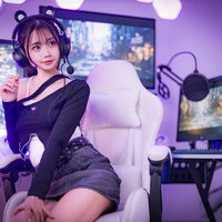 紫のネオン照明が映るゲーミングルームのゲーマー女子の写真