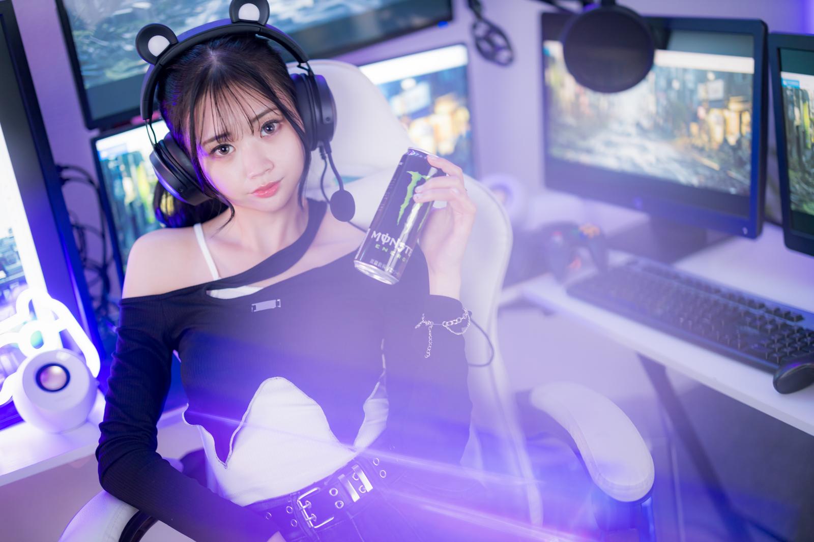 エナドリボトルを持つゲーミング女子がヘッドセット装着でゲーム配信する様子［モデル：れいか氏］