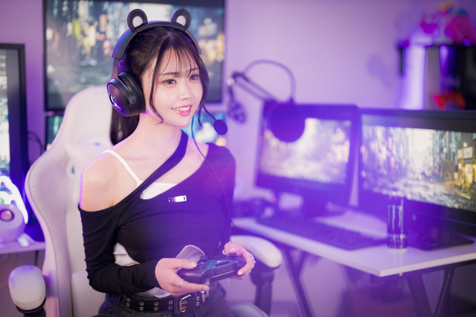 ゲーミングチェアに座り、ゲームパッドを持ってゲーム配信をする女性［モデル：れいか氏］