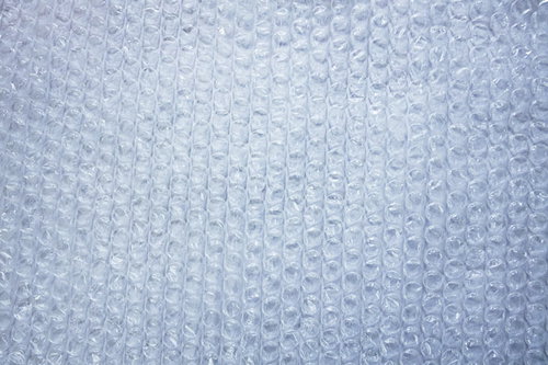 透明な気泡が規則正しく並ぶぷちぷちの緩衝材テクスチャー
