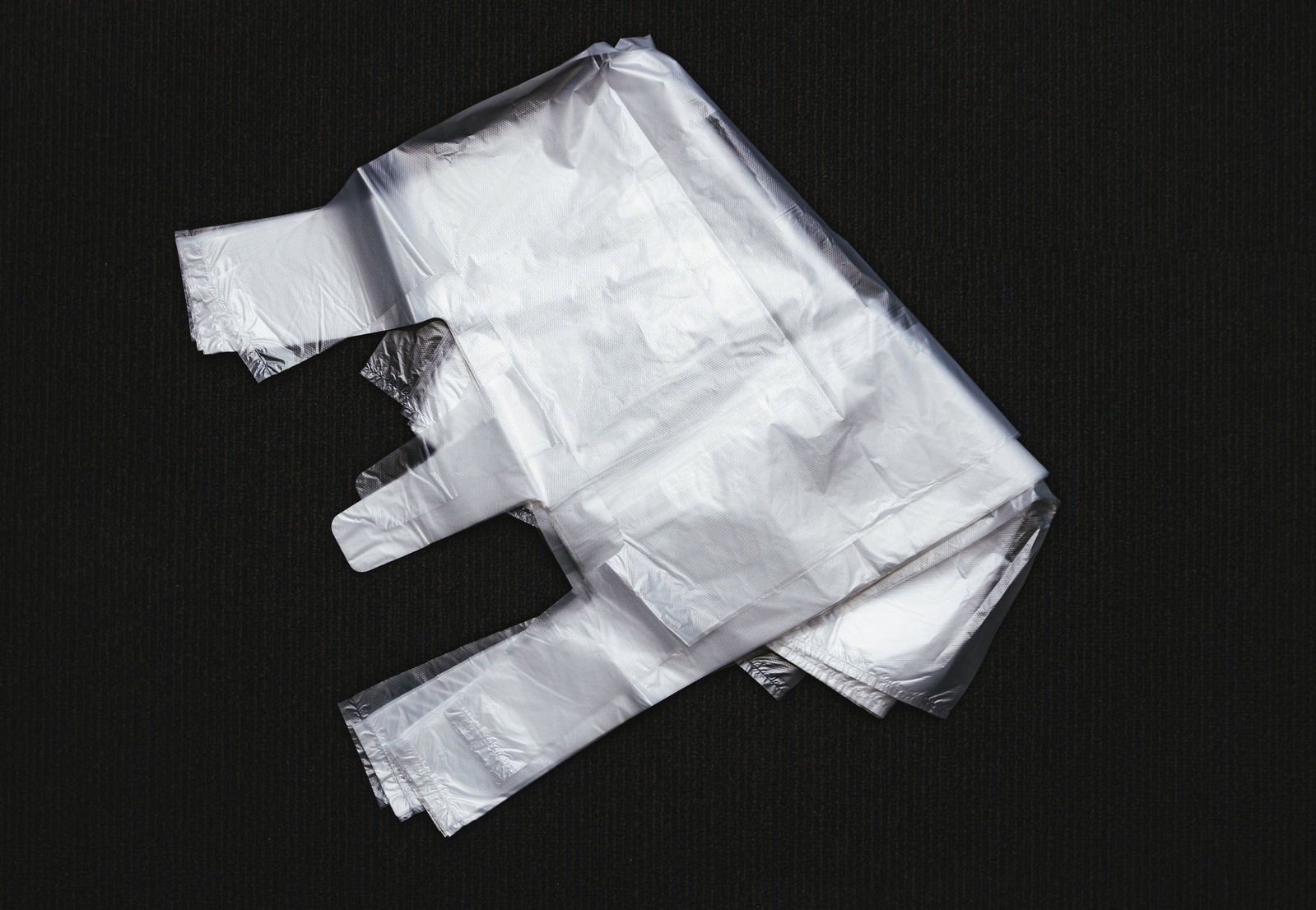 黒い背景にたたまれた白いレジ袋
