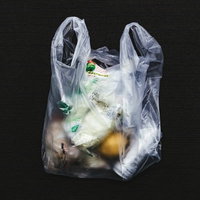 コンビニで買ったものをレジ袋に詰める買い物シーンの写真