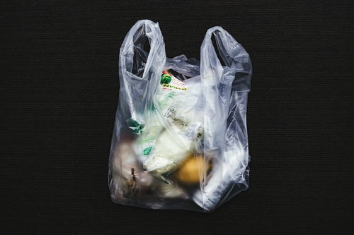 コンビニで買ったものをレジ袋に詰める買い物シーン