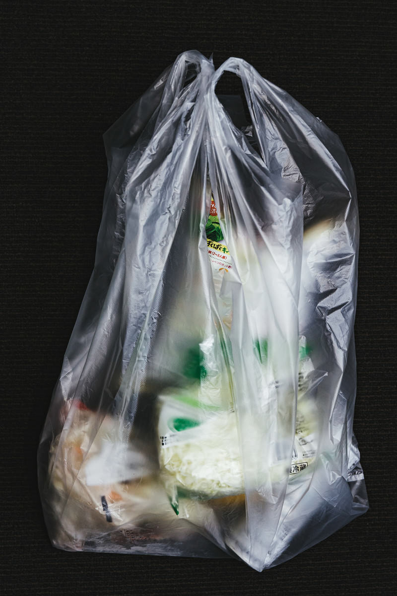 透明なビニール袋に入った食料品が黒い背景に置かれている