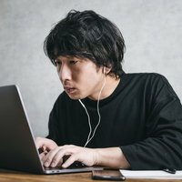こつこつとプログラムの改修を行うエンジニア男性の写真