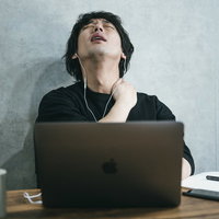 連日のリモートワークに限界を感じる男性のデスクの写真