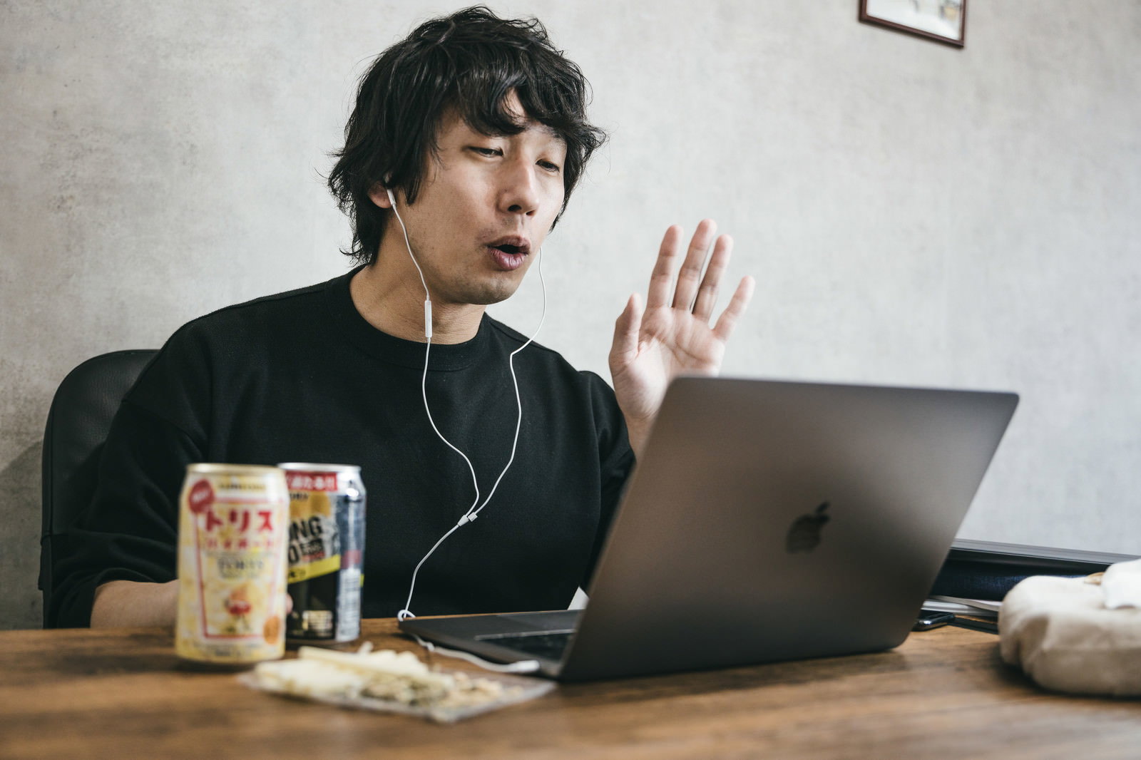ノートパソコンでリモート飲み会をする男性、ストロングゼロとおつまみが机にある［モデル：大川竜弥］