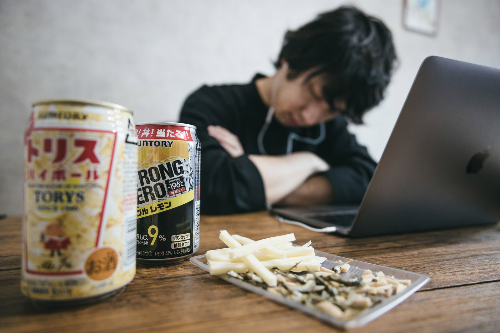 リモート飲み会中にパソコンの前で寝落ちする男性とストロングゼロの缶［モデル：大川竜弥］