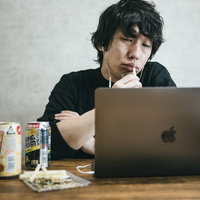 リモート飲み会の会話に入れない不満げな表情の男性の写真