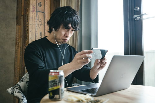 リモート飲み会でスクリーンショットを撮る男性