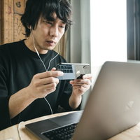 リモート会議前にスマホのフロントカメラで身だしなみチェックする男性の写真