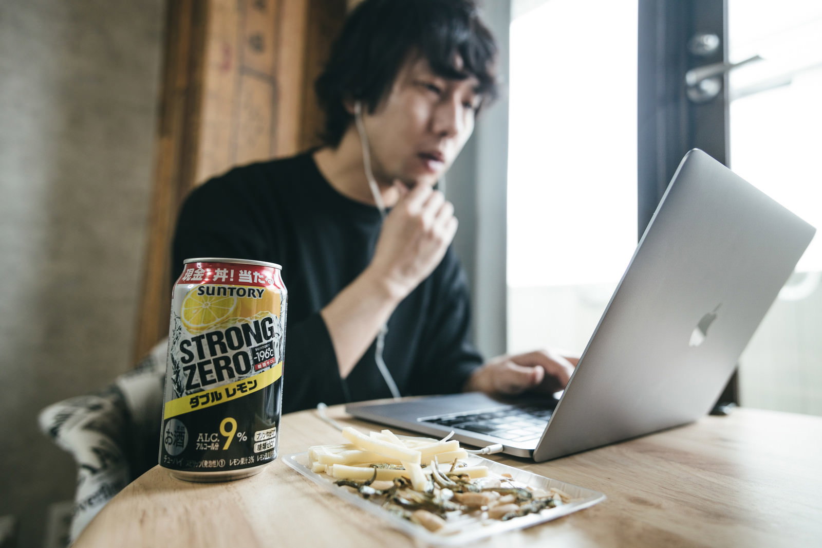 リモートワーク中のデスクに置かれたストロングゼロとおつまみ［モデル：大川竜弥］
