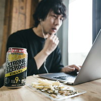 リモートワーク中のデスクに置かれたお酒とおつまみの写真