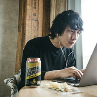 リモート飲みでバーチャル背景を設定しながらストロングゼロを飲む男性の写真