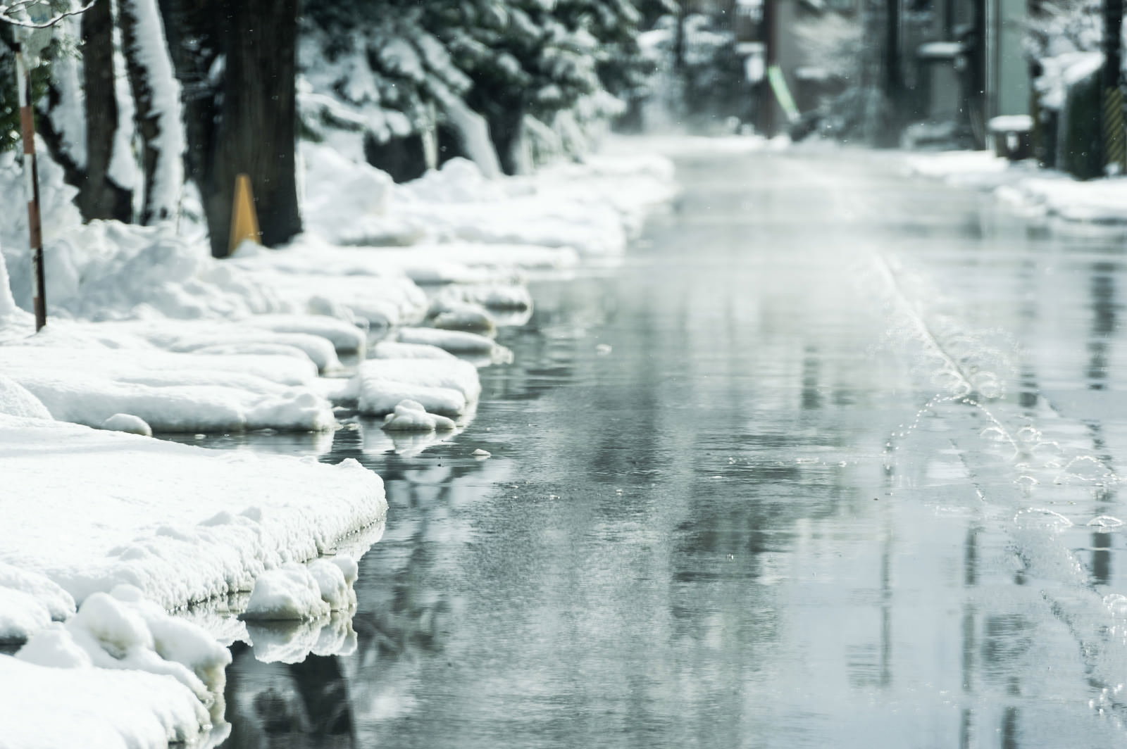 道路脇から水が噴出して雪を溶かしている消雪システムの様子