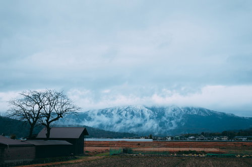 雪化粧した山々の頂上が雲に隠れた雪国の冬景色