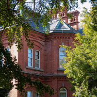 緑に囲まれた北海道庁旧本庁舎の赤レンガ造りの写真