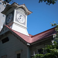 青空に映える札幌市時計台の赤い屋根と歴史的建造物の写真