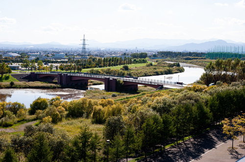モエレ沼公園の丘から見た河川と橋、遠方の街並み